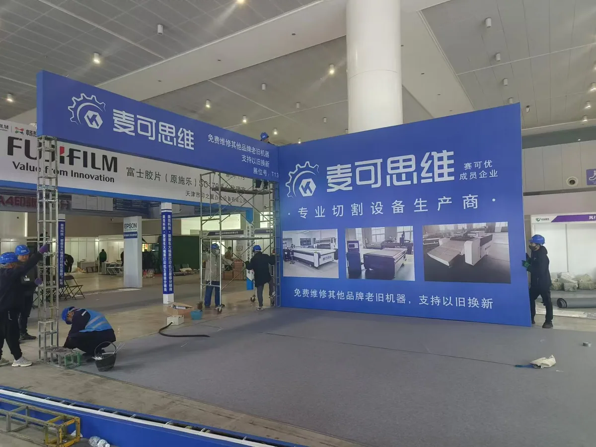 Installation crew assembling a large blue exhibition booth structure