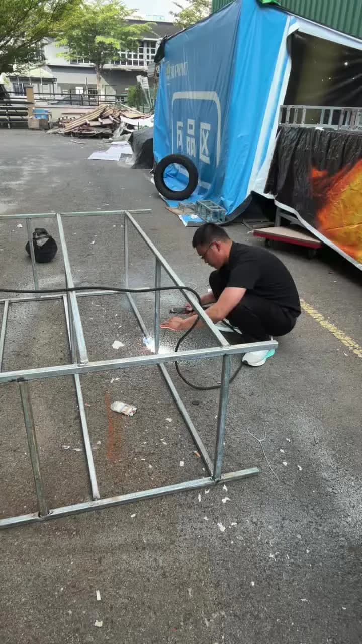 Metal display framework being welded in an outdoor production area