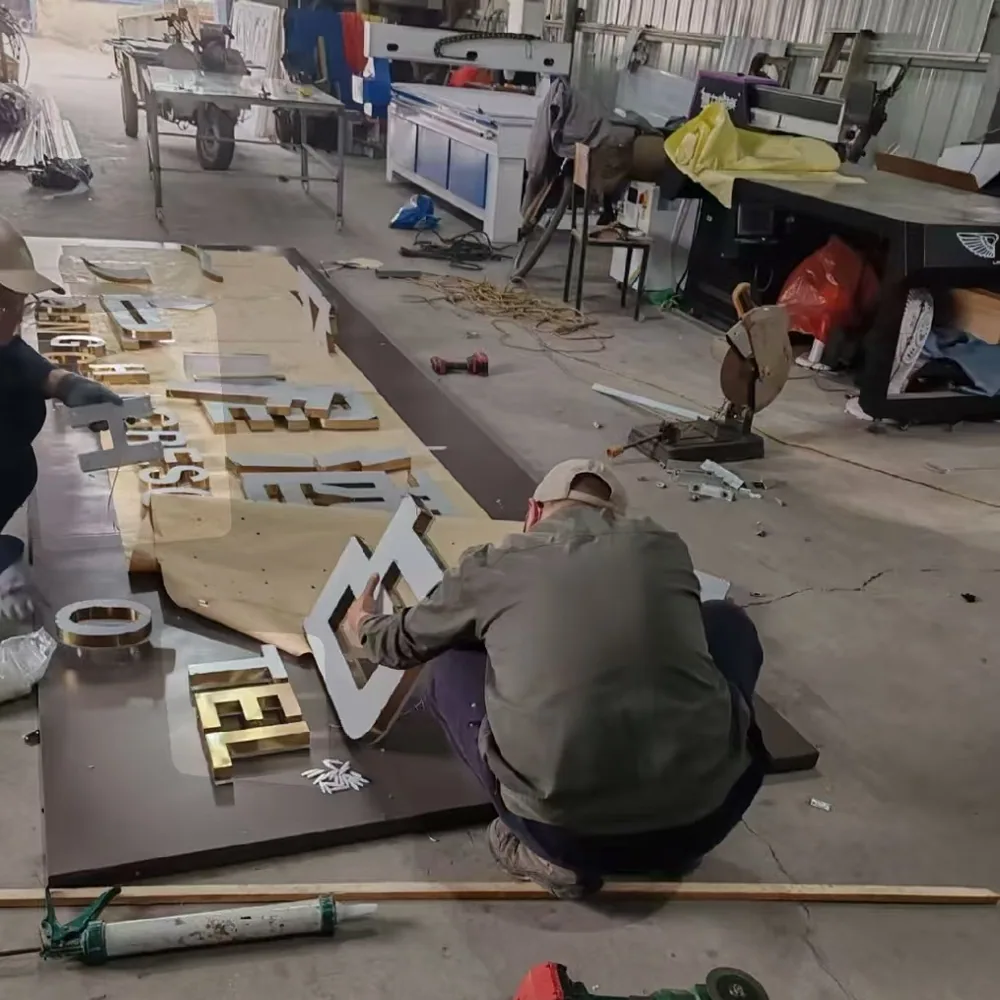 Dimensional gold and white signage letters being assembled in a fabrication workshop