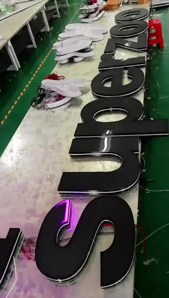 Dimensional letter bodies and illuminated components arranged during production