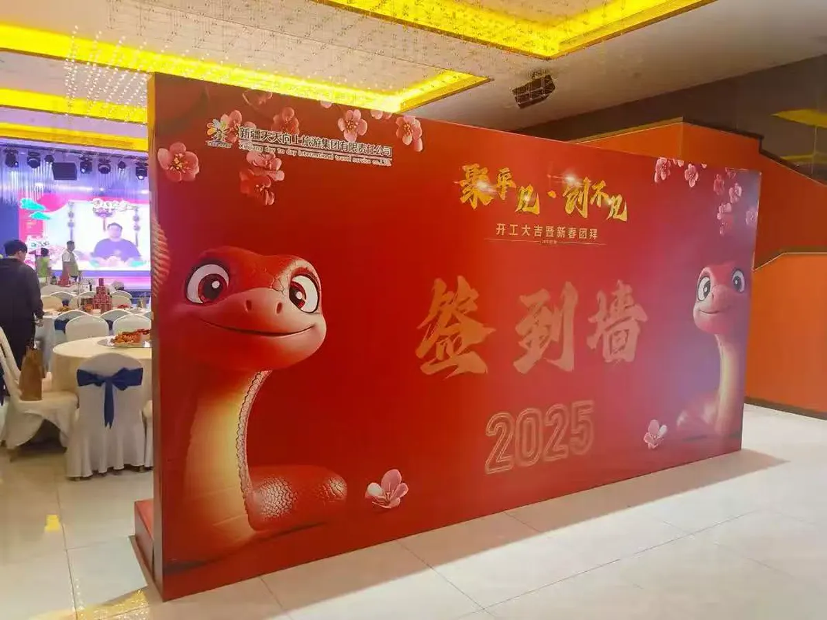 Red 2025 event backdrop with dimensional festive graphics in a banquet venue