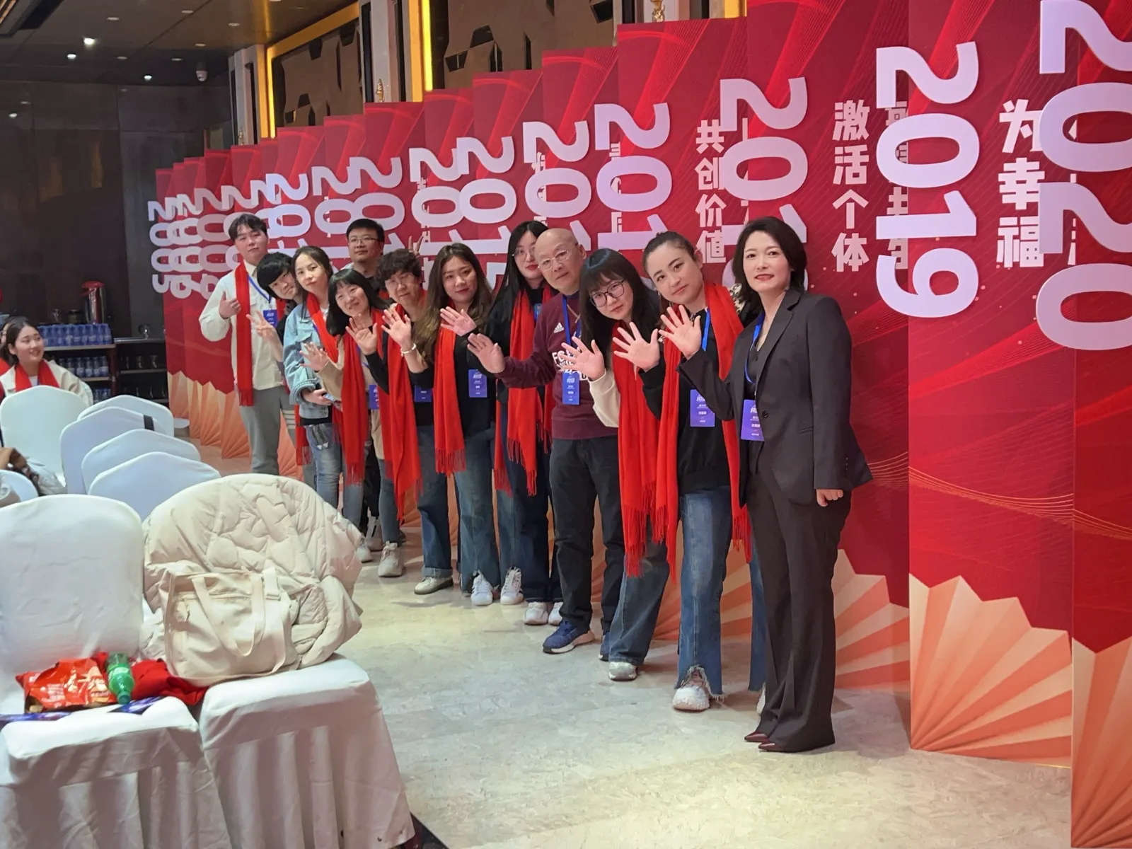 Event team standing in front of a large red freestanding conference backdrop