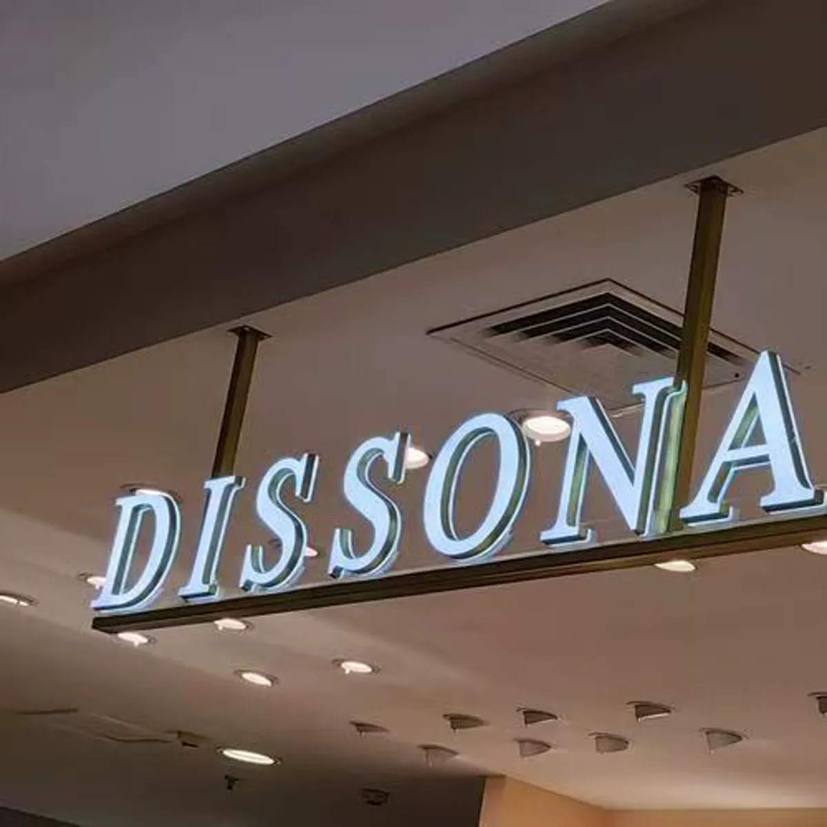 Illuminated dimensional restaurant lettering mounted below a ceiling feature